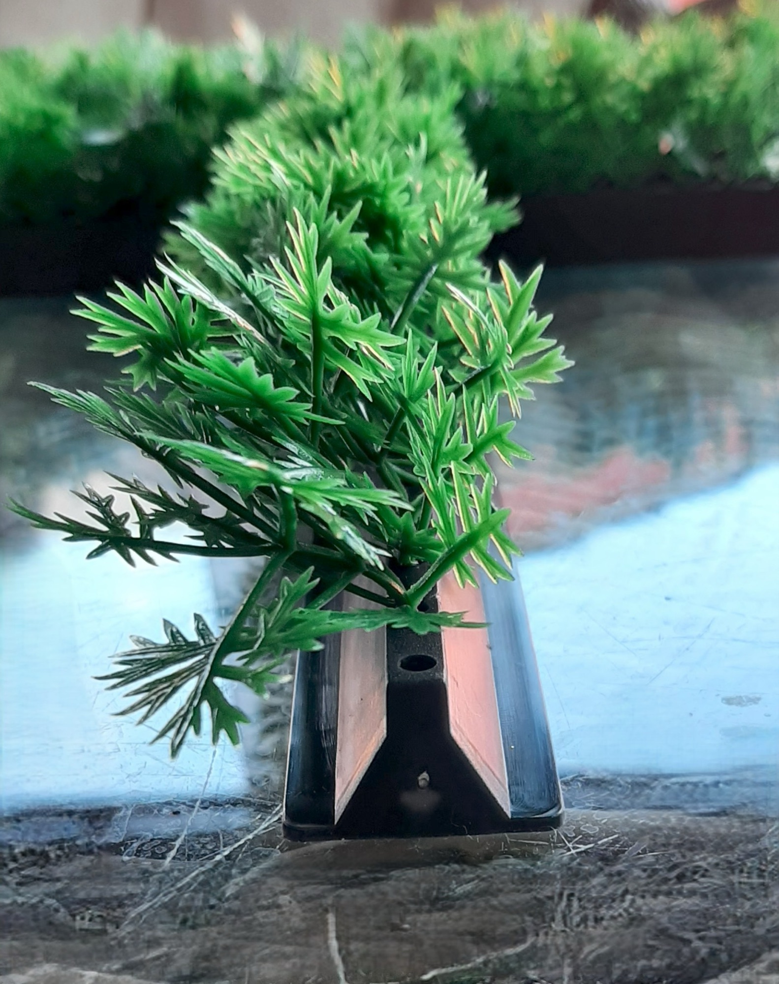 Detailfoto van het zwarte hoekprofiel van de decostrip met kunstgroen